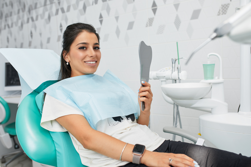 woman holding a mirror - Dental Implants in Federal Way WA woman holding a mirror - Dental Implants in Federal Way WA